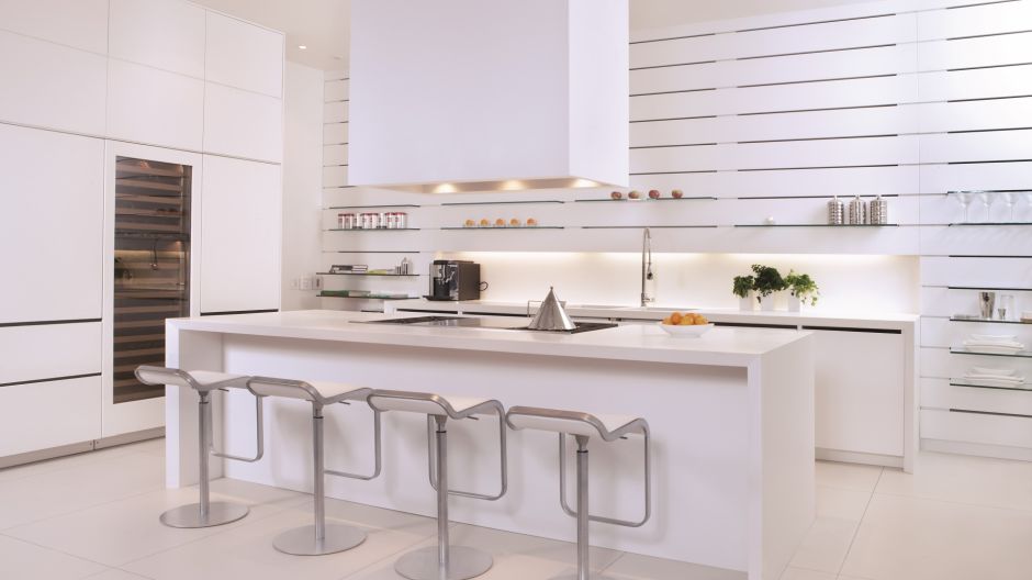 Metalowe hokery z białymi siedziskami przy wyspie kuchennej w kuchni w stylu minimalistycznym