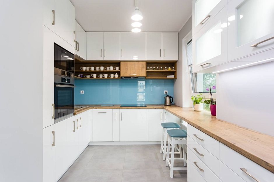 Niebieski panel szklany na backsplashu w małej kuchni