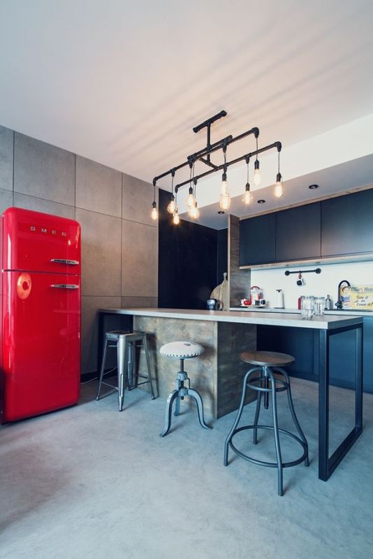 Industrialne hokery w kuchni z czerwoną lodówką w stylu retro